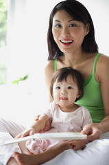 Mother with young daughter, smiling at camera