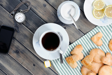Foods of the Italian breakfast with tea and biscuits on an old wooden table, photographed from above