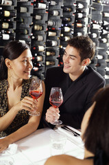 Young adults in restaurant, holding wine glasses