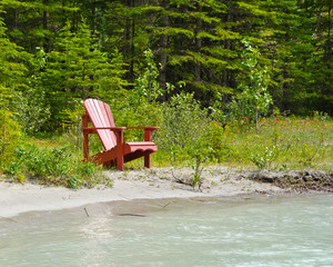 Fototapeta na wymiar Picnic bench (chair) on the beach of the river in Canada.