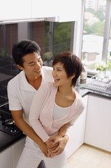 Couple embracing in kitchen