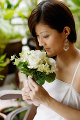 Young woman smelling bouquet of flowers