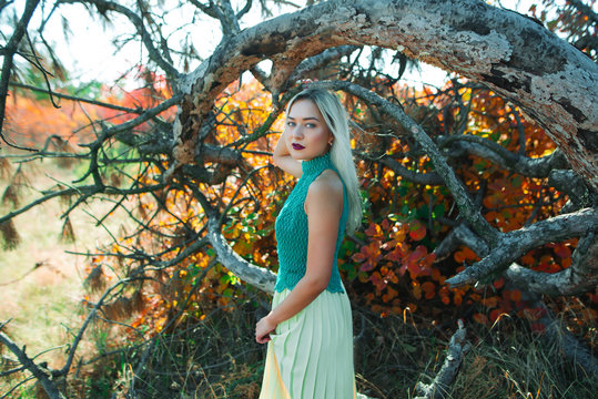 Beautiful Young Woman In A Green Shirt On A Forest Background.