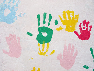 Huellas de manos pintadas en pared blanca