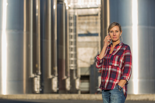 female worker speaking on mobile phone in an industrial area