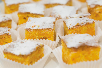 Group of yellow cakes wrapped in white paper
