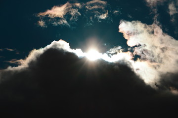 Die Sonne scheint durch eine dicke Regenwolke über den geteilten Himmel