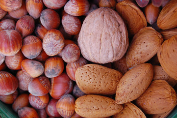 walnuts, hazelnuts and almonds in shells, one upon the other