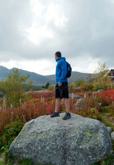 Man on a stone in a mountain peak