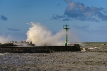 Fototapeta na wymiar Storm waves over the lighthouse in Darlowo. Baltic Sea. Poland.