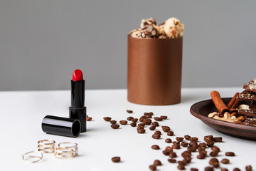 Decorative cosmetics coffee beans and chocolate over white background.
