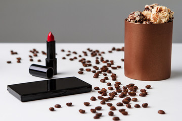 Decorative cosmetics coffee beans and chocolate over white background.
