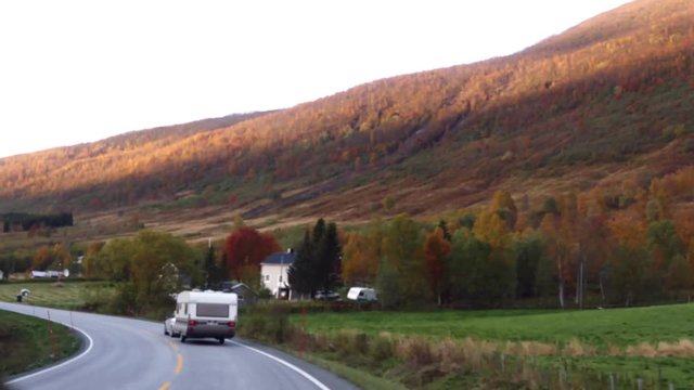 Driving on road E8 toward the city of Tromso, on a late evening sunset, in north Norway