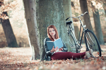 Lady reading under tree.