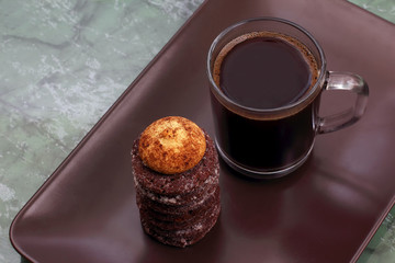 cup of hot black coffee with biscuits