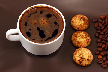 white cup of hot black coffee with biscuits and beans