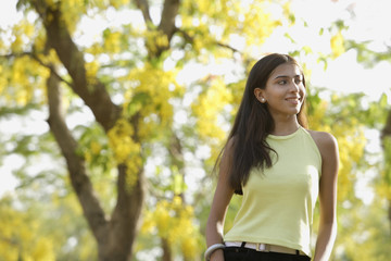 Fototapeta na wymiar teen girl standing under blooming tree
