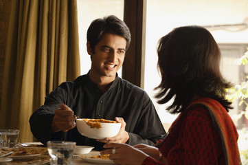 Fototapeta na wymiar couple at dinner table, man serving food