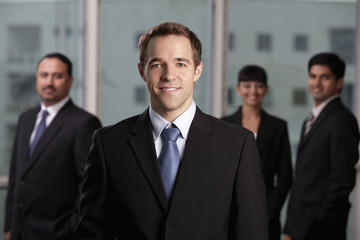 caucasian man standing in front of colleagues