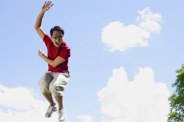 Man jumping in mid air, hand raised, mouth open