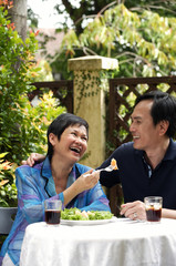 Mature couple laughing while dining in restaurant