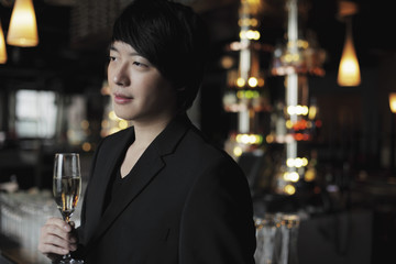 Profile of young man holding a glass of champagne.