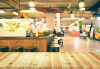 Naklejka na ściany i meble Defocused or blurred photo of food court montage with wood table top use for background.