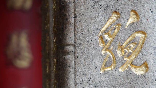 CU Gold Chinese symbol etched onto stone wall / Hong Kong, China