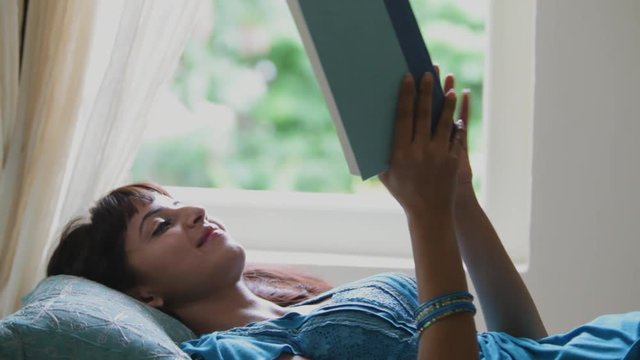MS Woman reading book at home