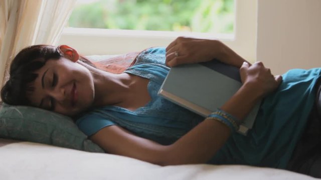 MS Woman reading book at home