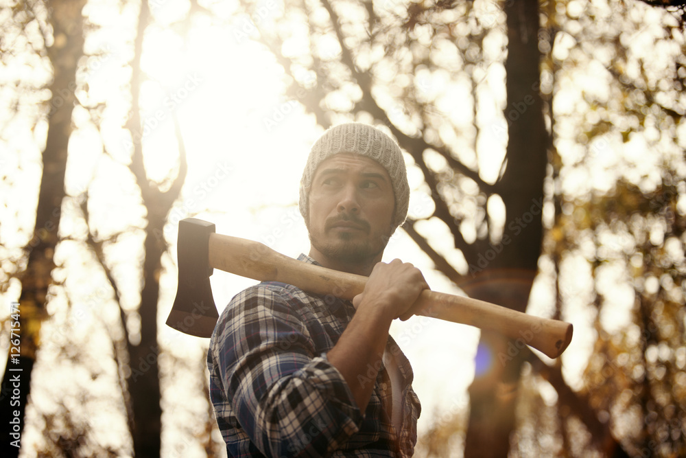 Wall mural Man with axe in the forest