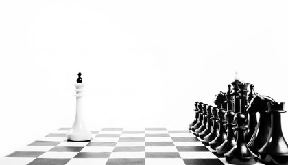 Alone white chess king in front of enemy team. Unequal fight. Concept with chess pieces against...