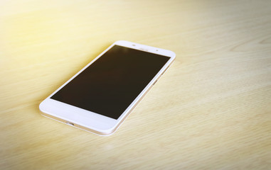 hand holding the white smartphone on blurred background