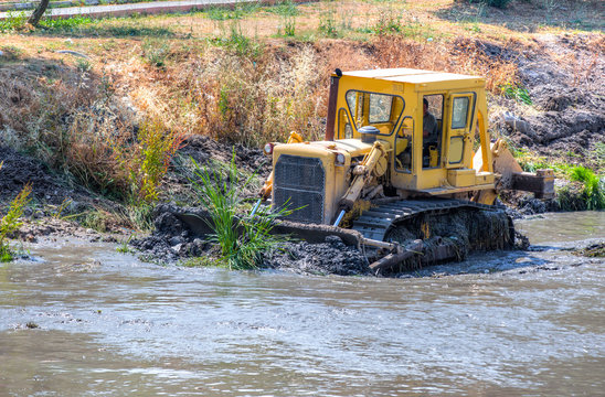 Grader working in river