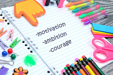 word motivation ambition courage write on notebook