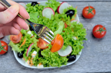 hand hold a folk with salad