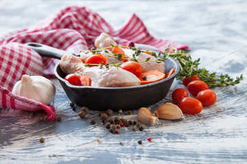 chicken legs and tomatoes in ware for roasting, selective focus