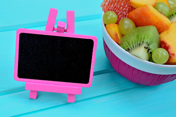 blackboard with salad fruit on table