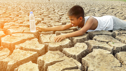 Child lying on cracked earth in the arid area