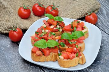 tomato bruschette with basil in dish on table