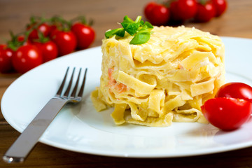 close-up of plate of pasta and smoked salmon with tomato