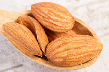 Closeup of almonds on wooden spoon