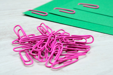 pile of pink paperclip with green paper