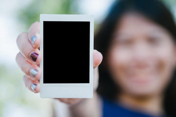 Asia Woman hold  photo instant on hand. Blank instant photo with nature background. relationship concept.