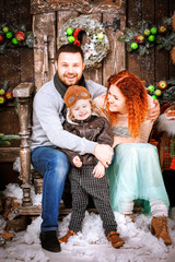 Christmas happy family of three persons and fir tree with gift boxes new year winter decorated background