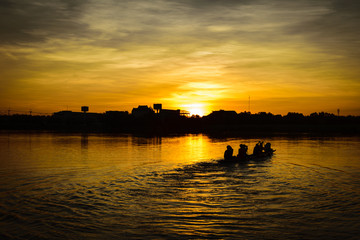 Fototapeta na wymiar people paddle in the lake at sunset time, silhouette, teamwork concept