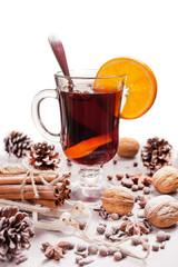 One glass of hot mulled wine and a slice of orange, spices, pine