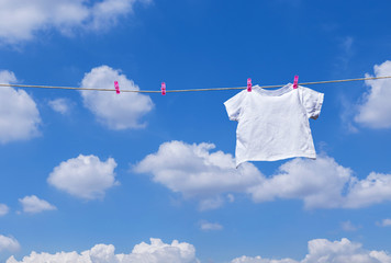 plain white T- shirt hanging on clothes line against blue sky - Powered by Adobe