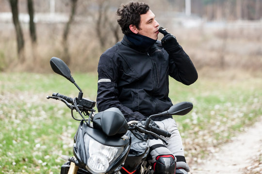 Biker sitting on motorcycle and smoking his cigarettes