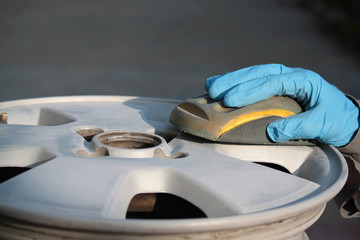 uomo carrozziere a lavoro su ruota auto